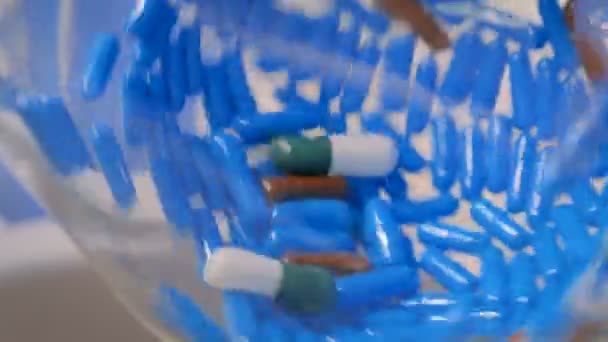 Vista de cerca de las píldoras en la bombilla de vidrio giratorio en la farmacia — Vídeos de Stock