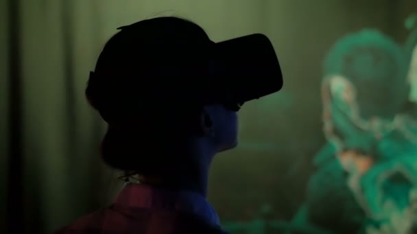 Jeune femme utilisant casque de réalité virtuelle à l'exposition interactive sombre — Video