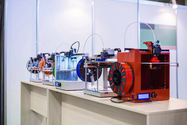 Three dimensional 3D printers during work at modern technology exhibition
