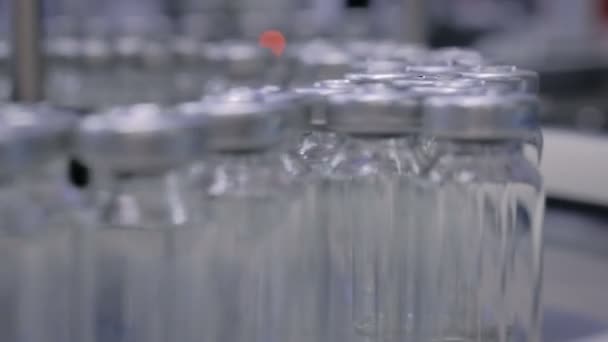 Concetto di tecnologia farmaceutica automatizzata - nastro trasportatore con bottiglie di vetro vuote — Video Stock