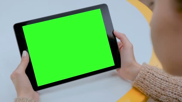 Жінка дивиться на планшетний комп'ютер з зеленим екраном вдома — стокове відео