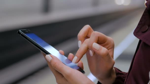 Mulher usando smartphone na plataforma do metrô — Vídeo de Stock