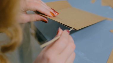 Kraft kağıdıyla çalışan profesyonel kadın dekoratör, tasarımcı.