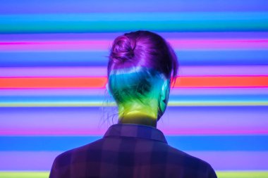 Çok renkli ışık aydınlatmaile modern sergiye bakan kadın