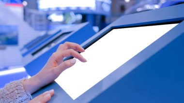 Sergide etkileşimli beyaz dokunmatik ekran kioskuna dokunan kadın