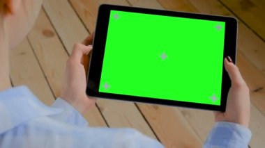 Boş yeşil ekranlı tablet bilgisayara bakan kadın - kroma anahtar kavramı