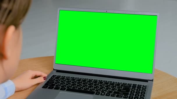 Vrouw op zoek naar laptop met lege groene display — Stockvideo