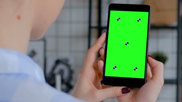 Mujer sosteniendo teléfono inteligente negro con pantalla verde en blanco - concepto de croma clave — Vídeos de Stock