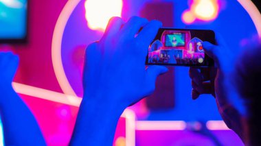 Akıllı telefonlu canlı müzik konserinin görüntülerini kaydeden eller.