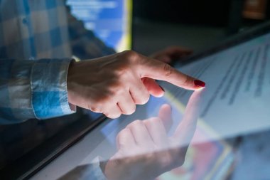 Modern müzede ya da sergide etkileşimli dokunmatik ekran kullanan kadın