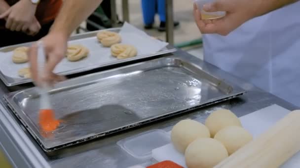 Шеф-повар намазывает масло на поднос для выпечки — стоковое видео