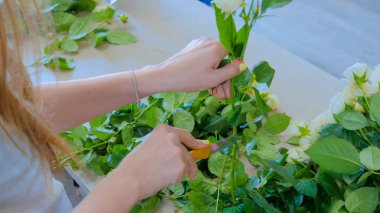 Stüdyoda çiçeklerle çalışan profesyonel bir çiçekçi.