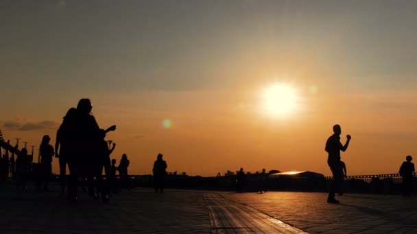 Lidé tančí při západu slunce — Stock video