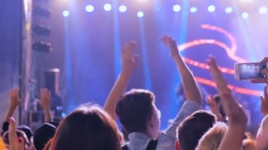 Gece açık hava konserinde sahne önünde parti gençler siluet