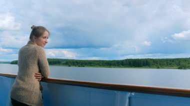 Cruise gemi güverte üzerinde duran ve nehirde seyir genç kadın