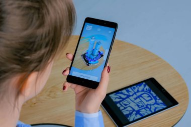 Ar uygulaması ile akıllı telefon kullanan ve sanal bina modelini yerleştiren kadın