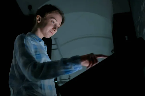 Woman using interactive touchscreen display at modern history museum