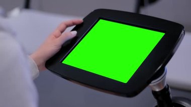 Yakın görünüm: boş yeşil ekranlı zemin duran tablet kiosk kullanan kadın