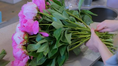 Çiçekçide çiçek toplayan kadın.