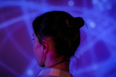 Genç bir kadın modern sanatsal sergiye bakıyor.