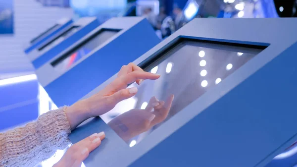 Vrouw met behulp van interactieve touchscreen display op technologie tentoonstelling — Stockfoto