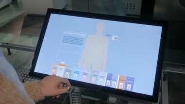 Modern müzede ya da sergide etkileşimli dokunmatik ekran kullanan kadın