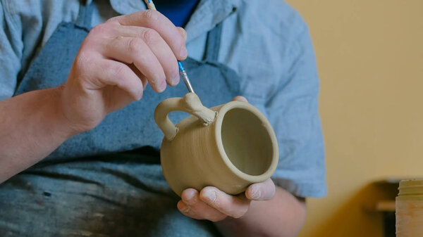 Professional male potter working in workshop, studio