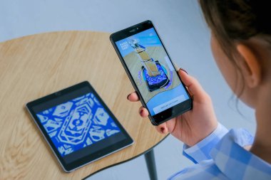 Mimari artırılmış gerçeklik uygulaması ile akıllı telefon kullanan kadın