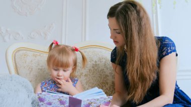 Genç anne ve küçük kızı fotobook 'a benziyorlar.