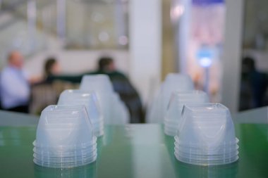 Plastik enjeksiyon makinesinin taşıyıcı bandında yiyecek kapları yığını