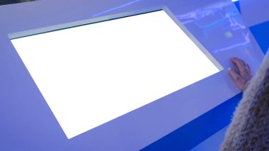 Beyaz ekran konsepti - sergide boş beyaz ekran kioskuna bakan kadın