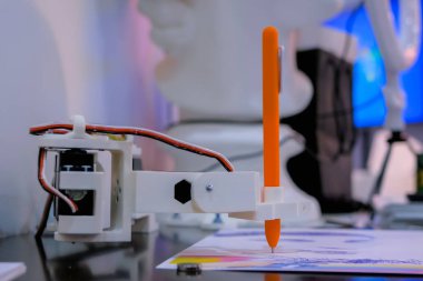 Robot fütüristik sergisinde portre çizen turuncu kalemli robot kol