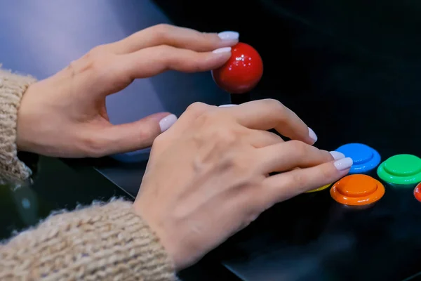 Γυναίκα παίκτης παίζοντας ρετρό παιχνίδι arcade μηχάνημα και πιέζοντας φωτεινά κουμπιά — Φωτογραφία Αρχείου
