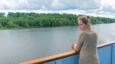 Cruise gemi güverte üzerinde duran ve nehirde seyir genç kadın