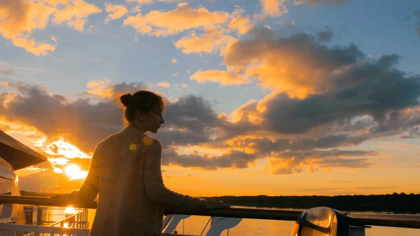Frau bewundert Sonnenuntergang vom Deck des Kreuzfahrtschiffes — Stockfoto