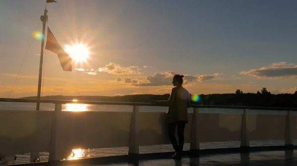 Frau bewundert Sonnenuntergang vom Deck des Kreuzfahrtschiffes — Stockfoto