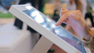 Şehir sergisinde etkileşimli dokunmatik ekran kullanan kadın