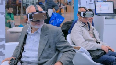 Yaşlılar sanal gerçeklik kulaklığı kullanıyor.