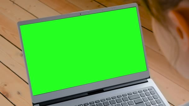 Mujer mirando el ordenador portátil con pantalla verde vacía — Vídeos de Stock