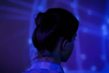 Genç bir kadın modern sanatsal sergiye bakıyor.