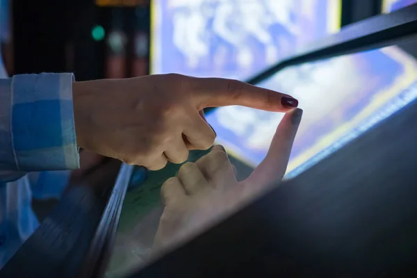 Woman using interactive touchscreen display at modern museum or exhibition