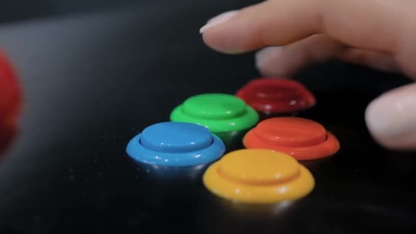 レトロなアーケードゲーム機で明るいボタンを押す女性の手-閉じるビュー — ストック動画