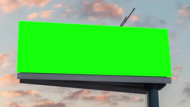 Timelapse - panneau d'affichage vert vierge et nuages couchant de soleil mouvants contre ciel bleu — Video