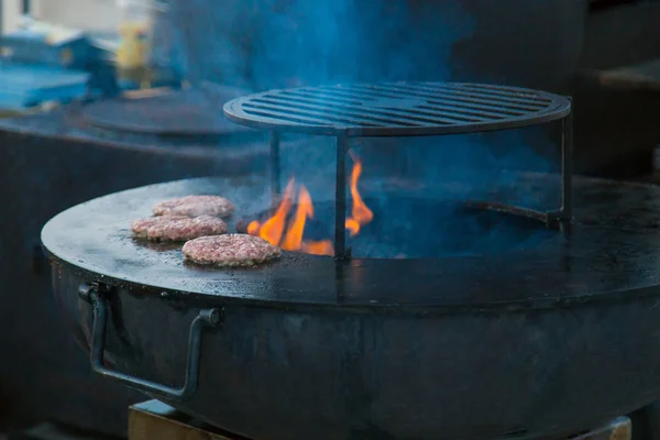Processo de preparação de hambúrgueres no festival de comida de rua — Fotografia de Stock