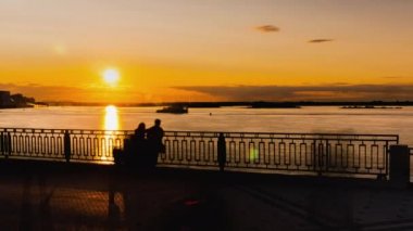 Zaman Alanı - Rıhtımdaki nehirde dramatik renkli altın suşiye hayran olan çift