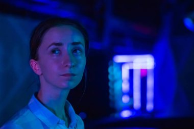 Genç bir kadın modern sanatsal sergiye bakıyor.