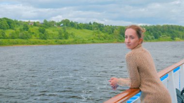 Cruise gemi güverte üzerinde duran ve nehirde seyir genç kadın