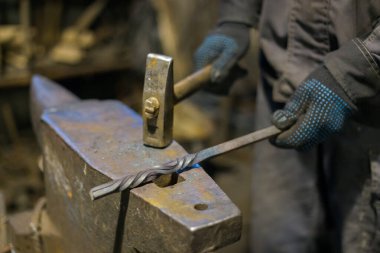 Demirci erimiş metal dövüyor.