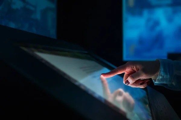 Vrouw met interactieve touchscreen display in modern museum of tentoonstelling — Stockfoto