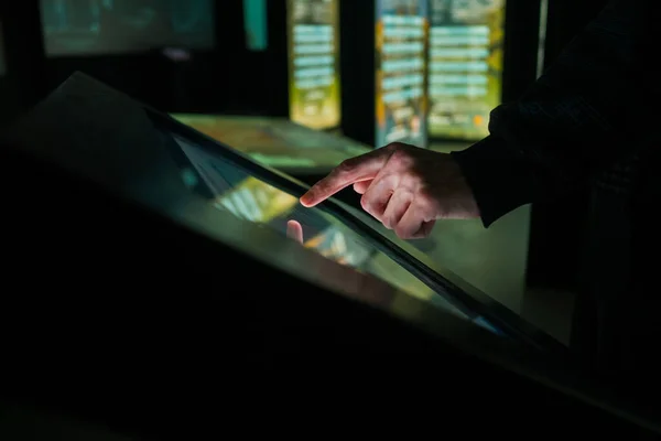Modern müze veya sergide interaktif dokunmatik ekran kullanan adam